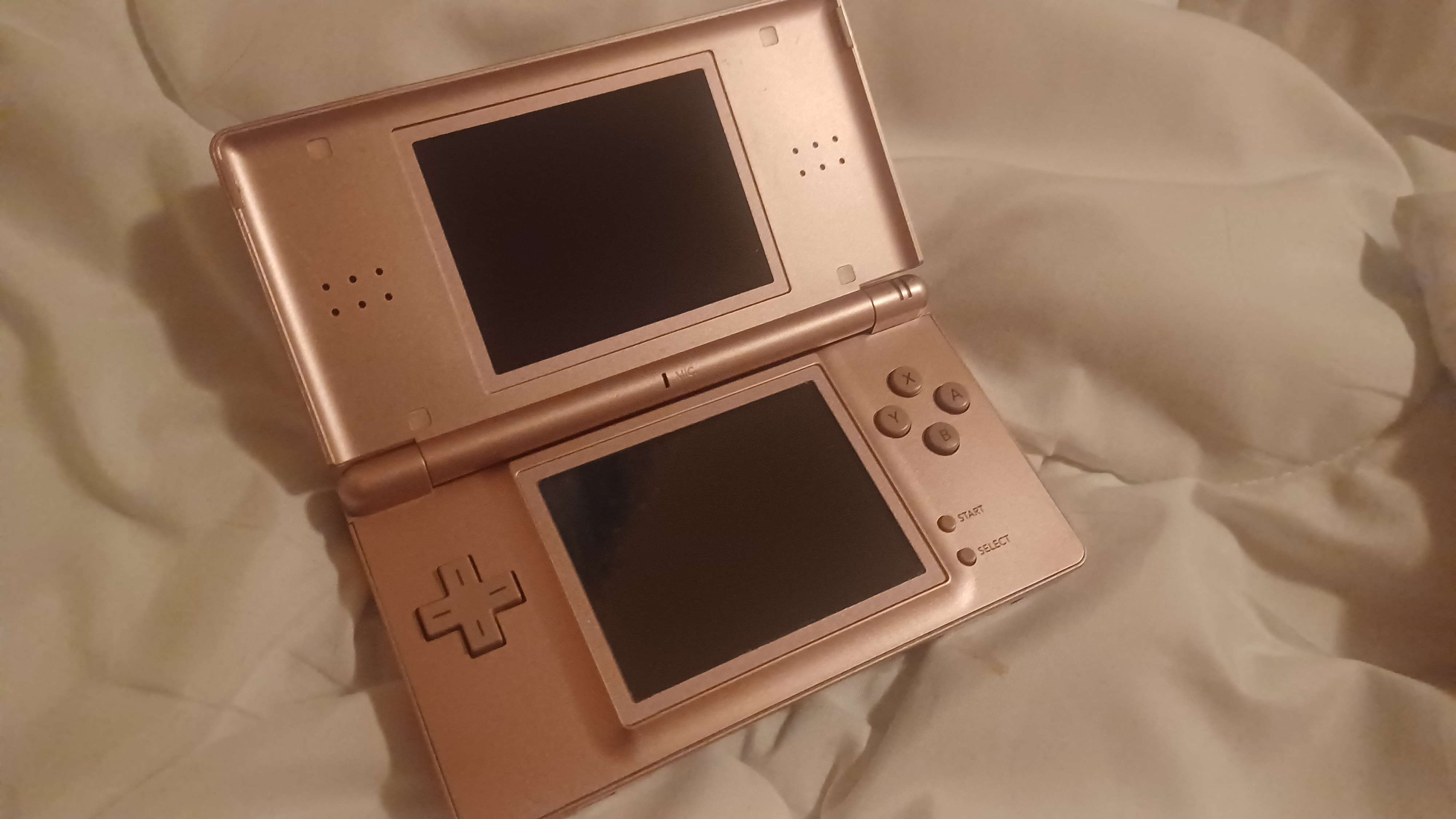 a photo of a rose gold nintendo DS.